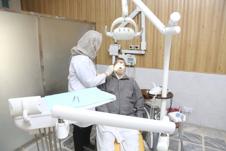 A dentist checking a patient's teeth in the dental department at Muazzam Hospital