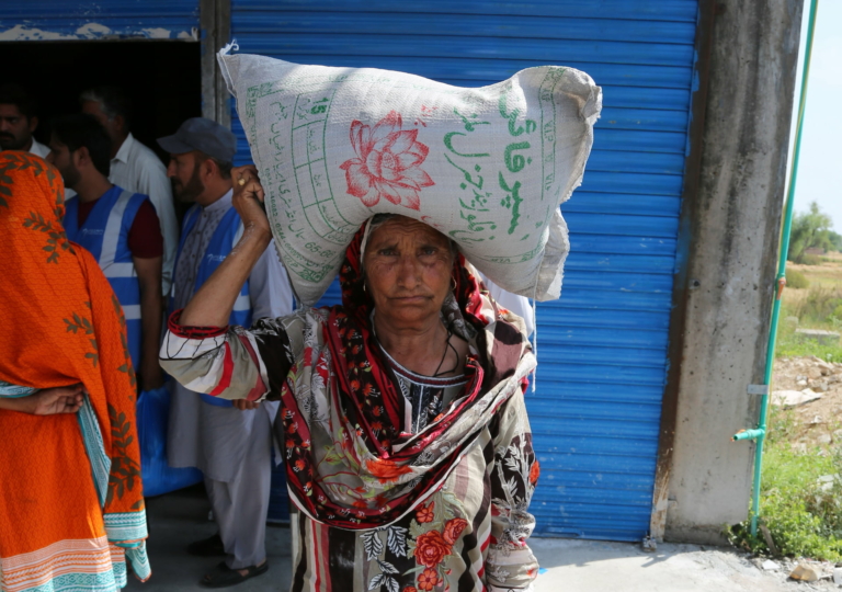 An old woman carrying a bag of food on her head received through Muazzam Foundation's feed the fasting project