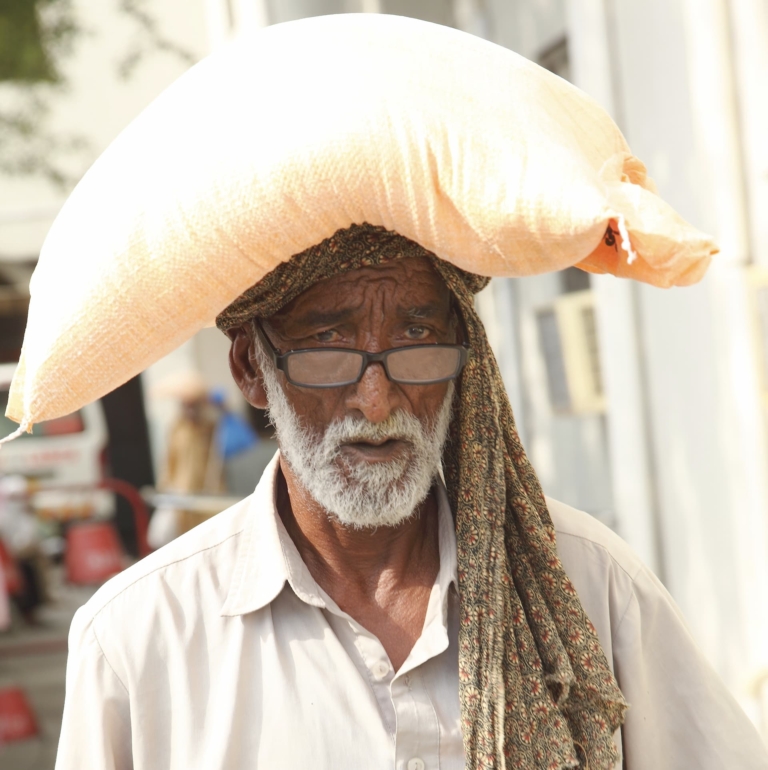 An old man carrying food on his head received from a food project in Pakistan