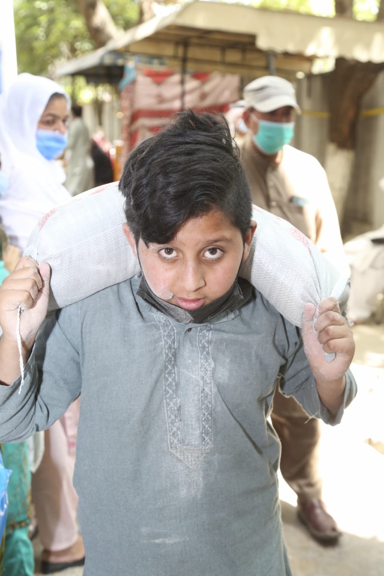 A boy carrying a food pack in Pakistan