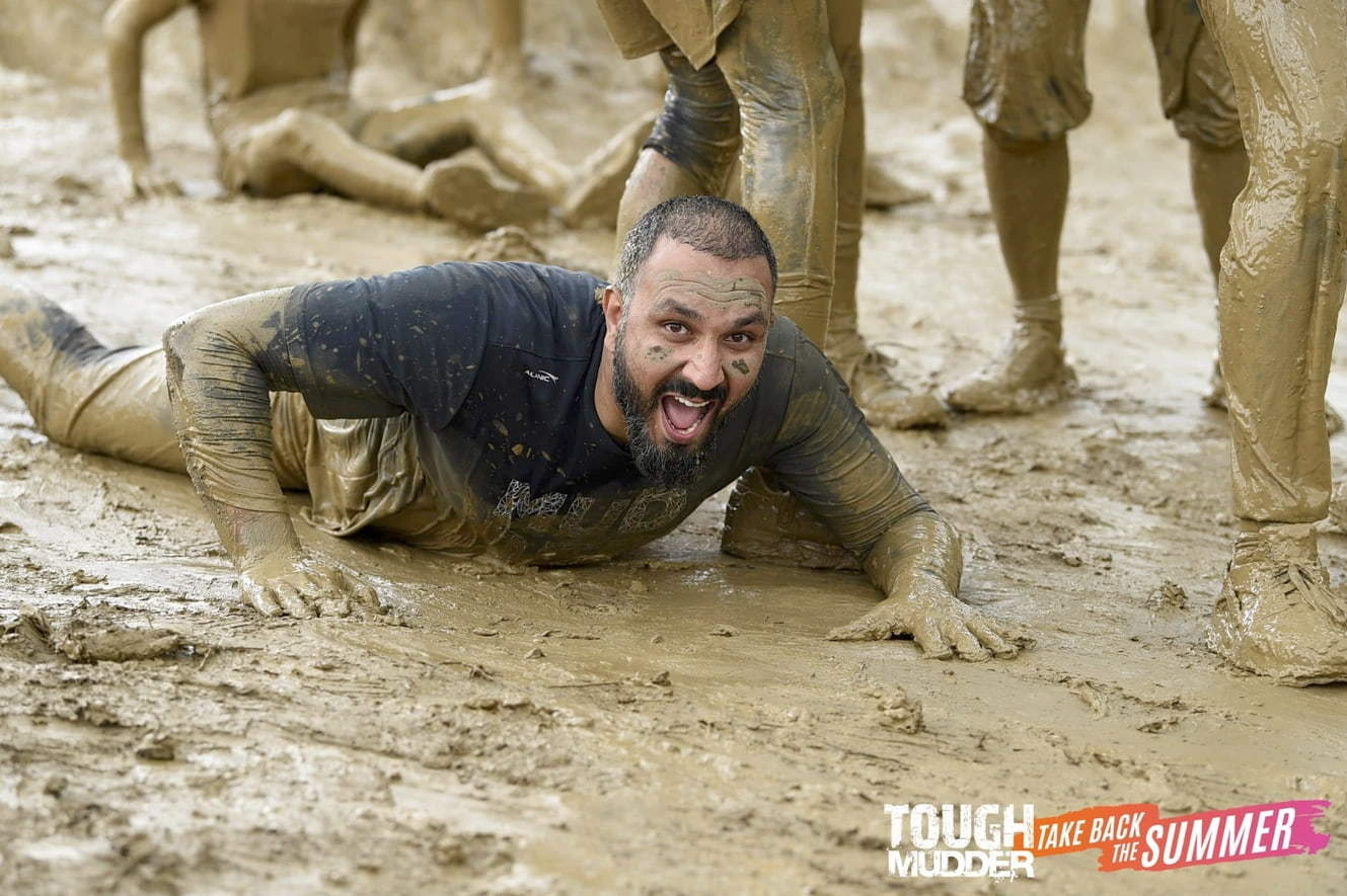 A man lying on the ground during a charity tough mudder event