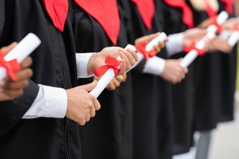 A row of graduates holding their diplomas achieved through Muazzam Foundation's Higher Education Sponsorships