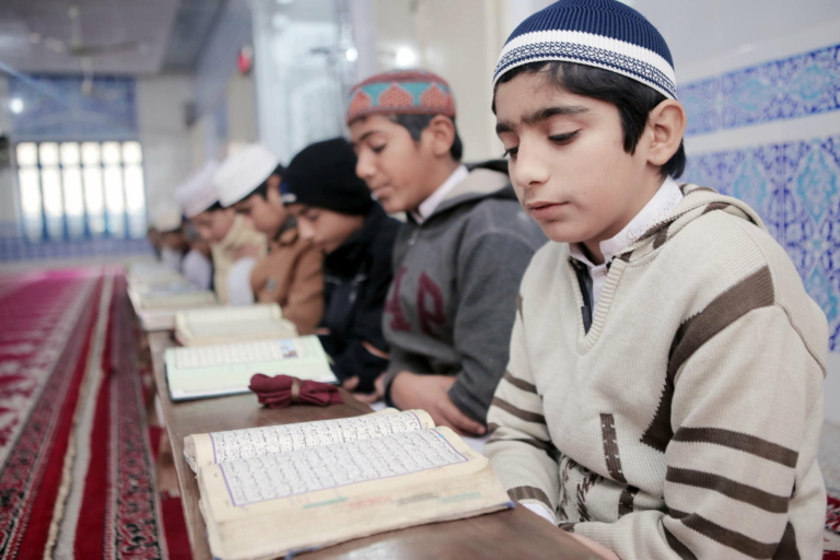 A line of children sat down to read and learn the Quran as part of Muazzam Foundation's Hifz Sponsorship project