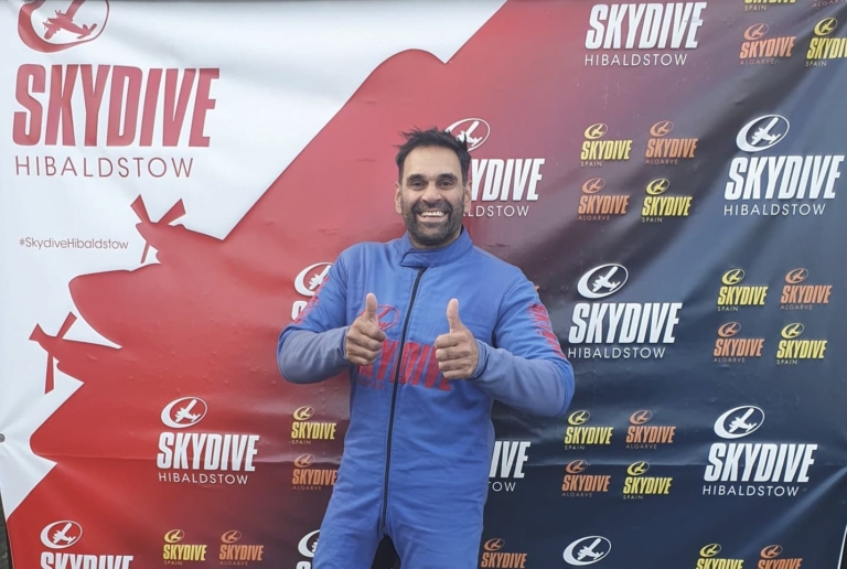 A man smiling with his thumbs up after a sponsored charity skydive at Skydive Hibaldstow