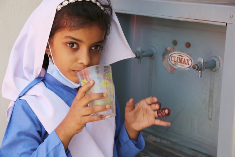A young girl drinking clean water provided by Muazzam Foundation's clean water project as part of the natural disaster relief programme.
