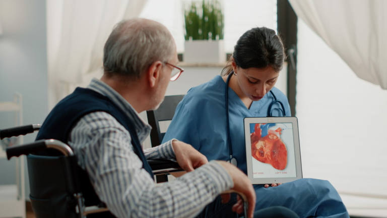 A nurse holding a tablet with a figure of a heart for a cardiology patient in Pakistan