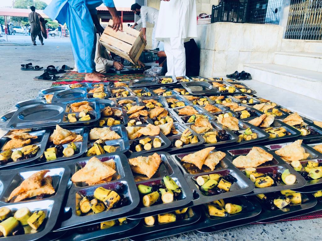 Lots of trays of food being prepared for the needy in Pakistan