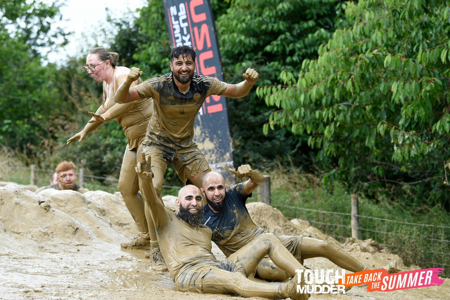 People covered in mud having fun at a charity tough mudder event for 2023